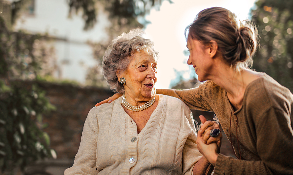 happy elderly woman with other woman smiling